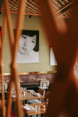 Restaurant mit gedeckten Tischen und Porträt einer vietnamsischen Frau